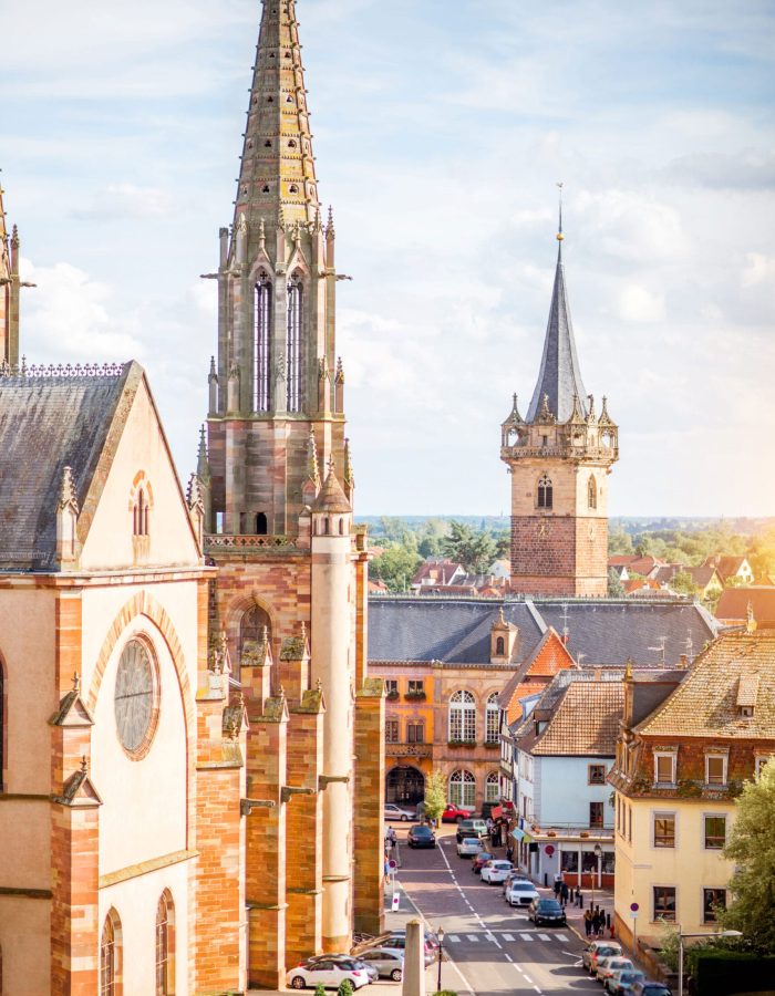 cityscape-view-on-the-old-cathedral-and-tower-in-obernai-village-during-the-sunny-day-in-alsace-region-france-scaled.jpg